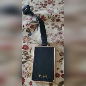 Tumi black and gold luggage tag